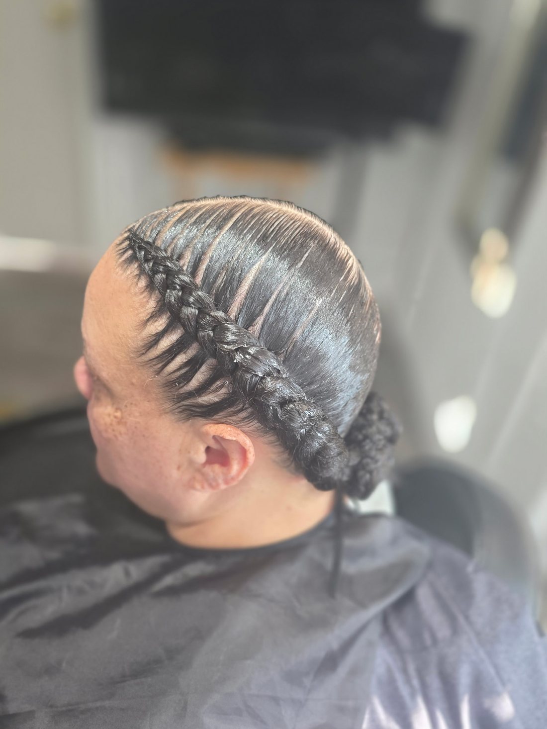 Sleek braid wrapped into a low bun